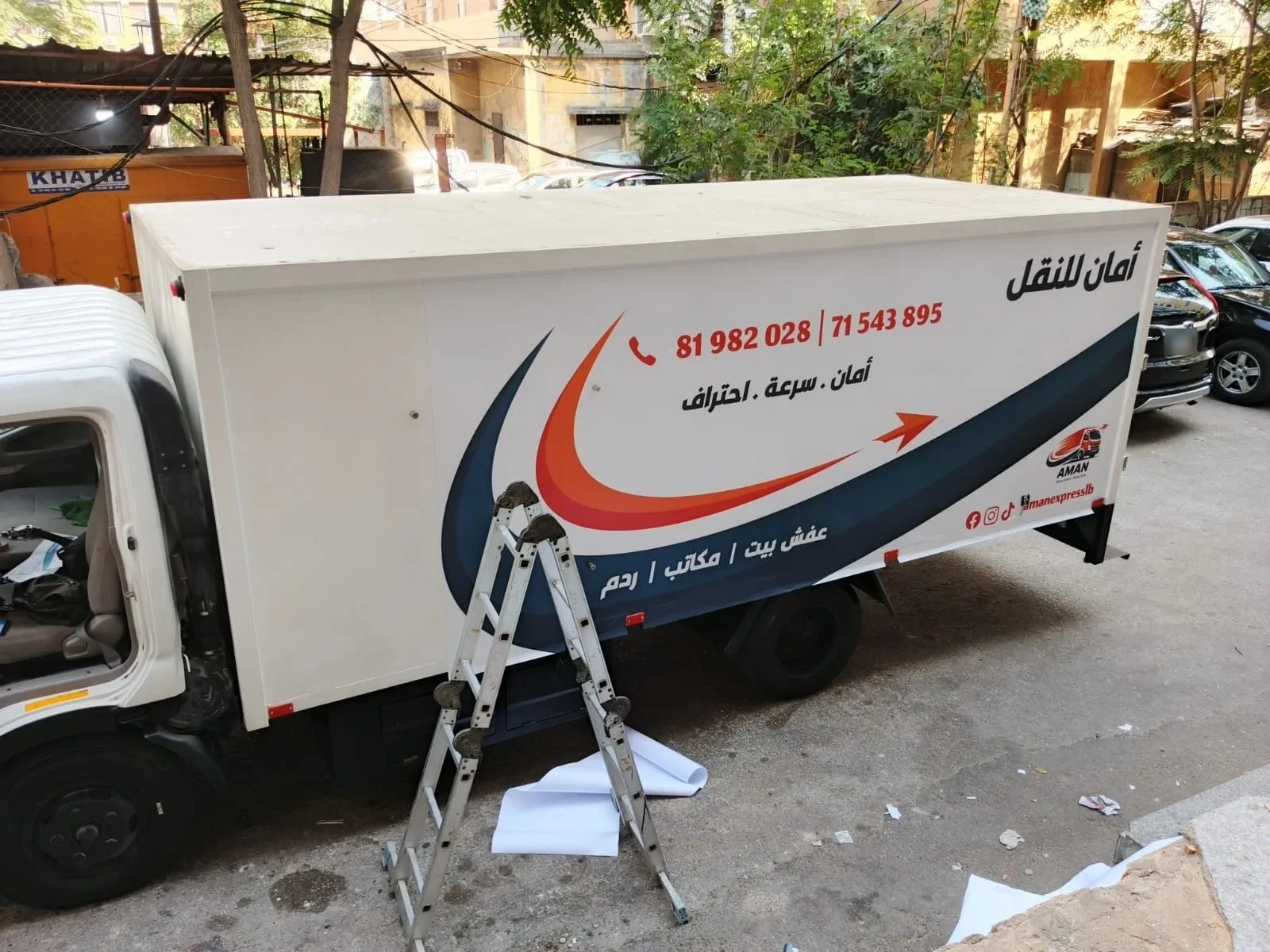 The full side of the truck wrapped, a ladder and backing paper still beside it